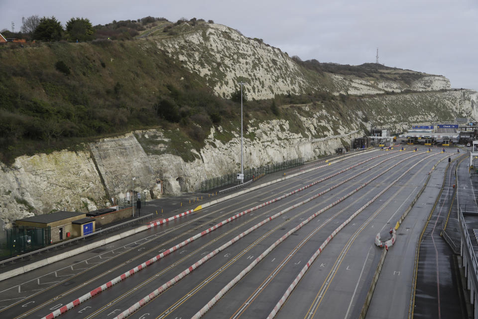 The ferry terminal check-in is seen empty alongside the White Cliffs of Dover, whilst the Port remains closed, in Dover, southern England, Tuesday, Dec. 22, 2020. Trucks waiting to get out of Britain backed up for miles and people were left stranded at airports as dozens of countries around the world slapped tough travel restrictions on the U.K. because of a new and seemingly more contagious strain of the coronavirus in England. (AP Photo/Kirsty Wigglesworth)