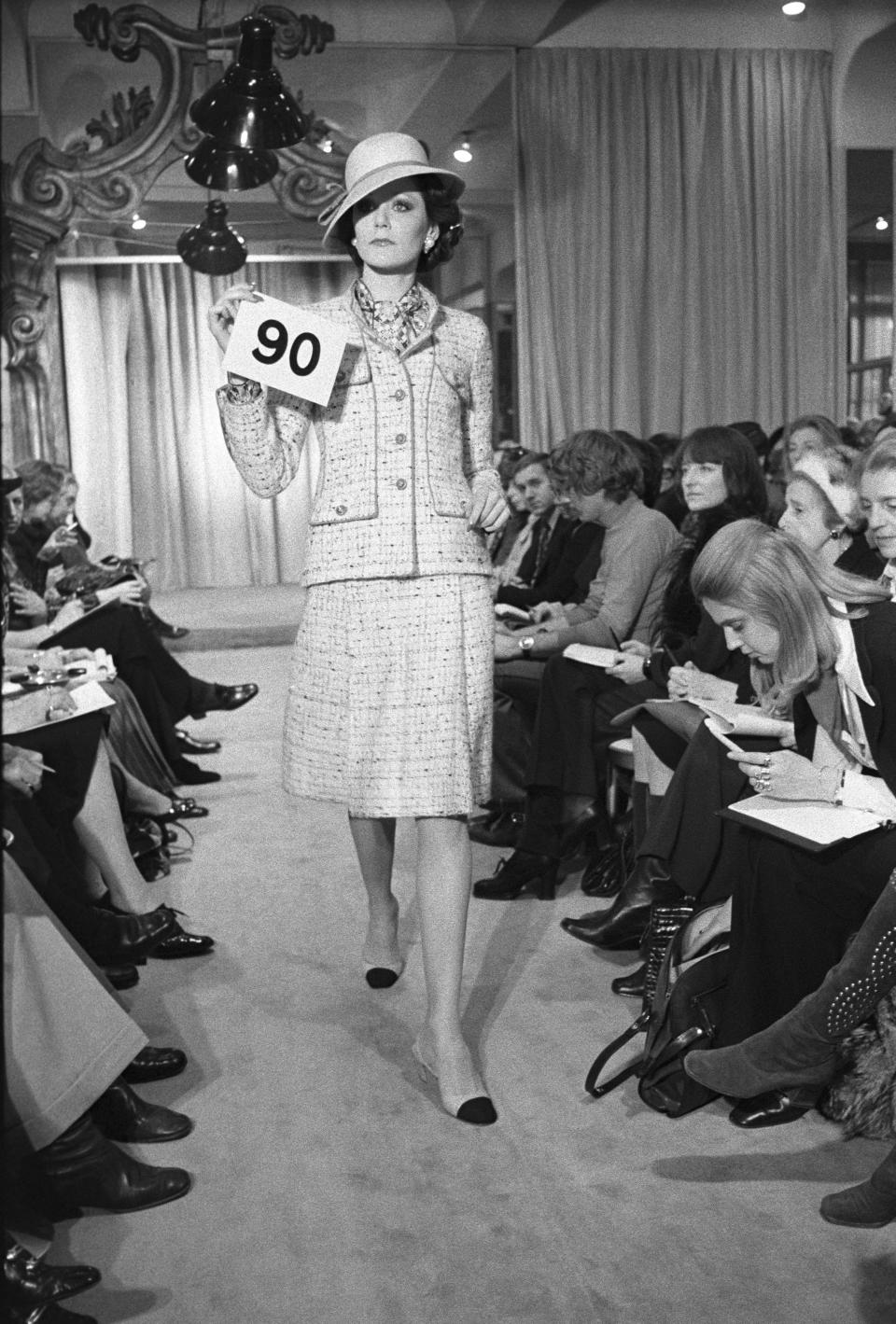 A model poses in Chanel&#x002019;s classic knit suit and accessories from the Chanel spring 1972 couture collection fashion show. This collection was designed with artistic director Gaston Berthelot. - Credit: WWD