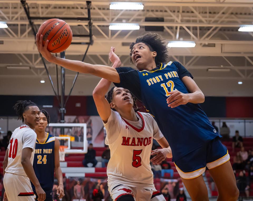 Stony Point guard Elijah Clemons stretches out for a shot under the basket as Manor guard Chris Colter Jr. defends during their Jan. 19 game at Manor. The Tigers rolled past Westlake in Tuesday night's regional quarterfinals to advance to this week's Region IV-6A tournament.