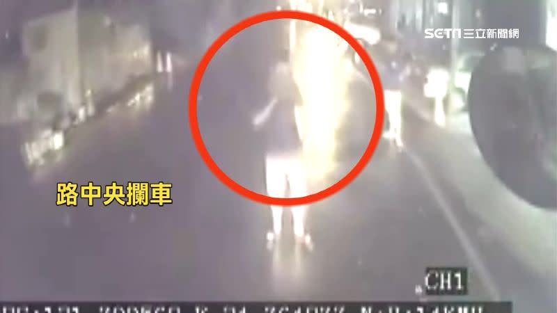 水電行業者站在馬路中間攔車。