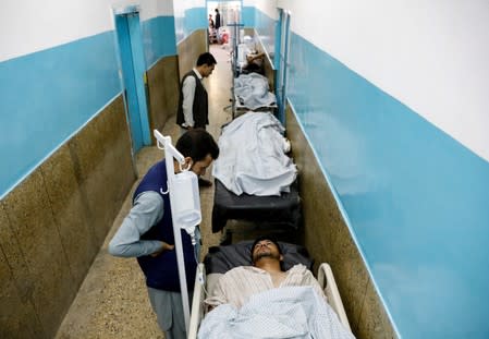 Injured men receive treatment in the hospital after sustaining wounds from a blast at a wedding hall in Kabul, Afghanistan