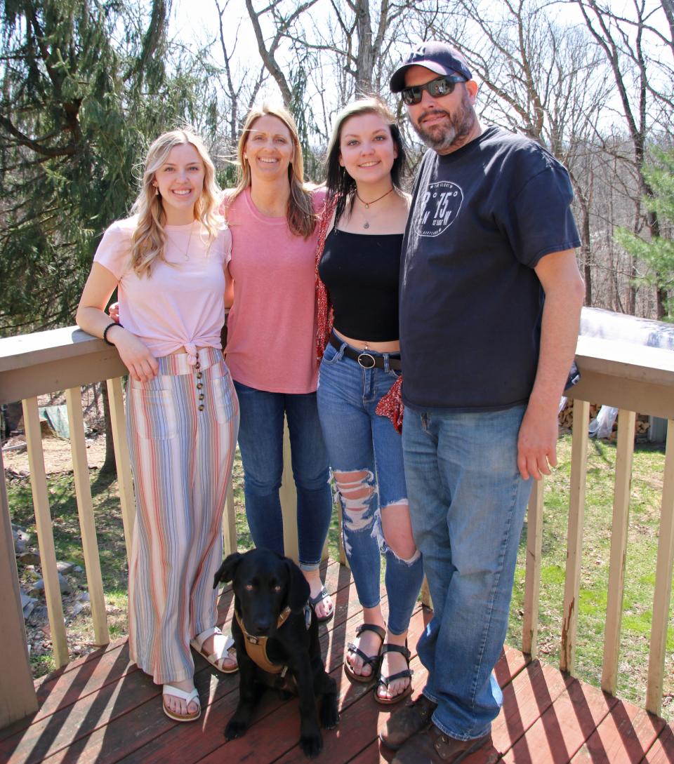 Jay Mills poses for a family photo in April of last year with, from left, daughter Chloe, wife Ami, daughter Brenna and, in front, his K9 companion Chase.