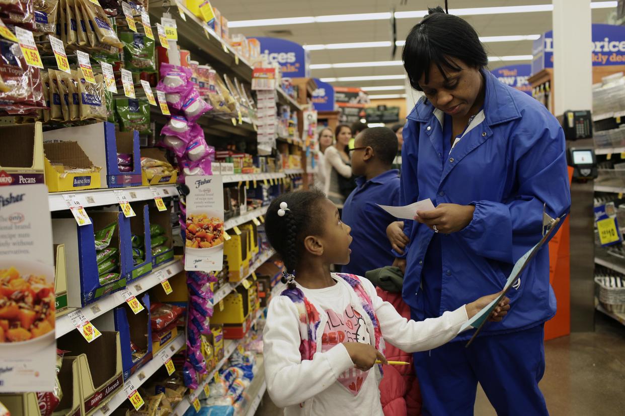 Anita Barksdale, right, helps her daughter Nicole Barksdale, 5, left, and her son Christopher Barksdale, 9, as they figure out the cost of ingredients for their sesame shrimp stir-fry recipe at a Kroger grocery store in Lake Orion, Michigan. (Credit: Joshua Lott,The Washington Post)