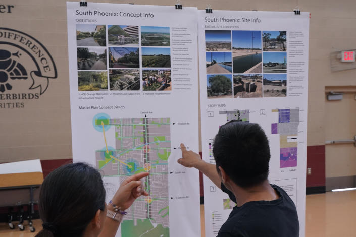 FILE - Residents attend an event hosted by Arizona State University graduate design students at Academia del Pueblo charter school, Friday, Sept 28, 2022, in Phoenix. Community members were learning how to organize and advocate for cooler, greener, healthier neighborhoods. As heat waves fueled by climate change arrive earlier, grow more intense and last longer, people over 60 who are more vulnerable to high temperatures are increasingly at risk of dying from heat-related causes. (AP Photo/Matt York,File)