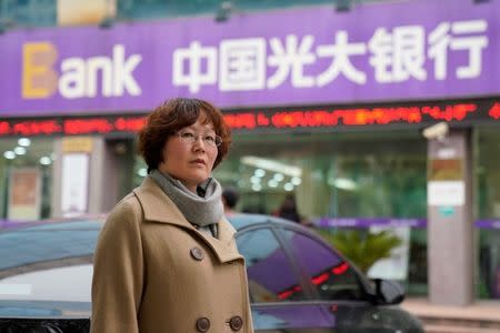 Anne Xing poses for pictures in front of the branch of China Everbright Bank in Shanghai, China, December 7, 2017. REUTERS/Aly Song