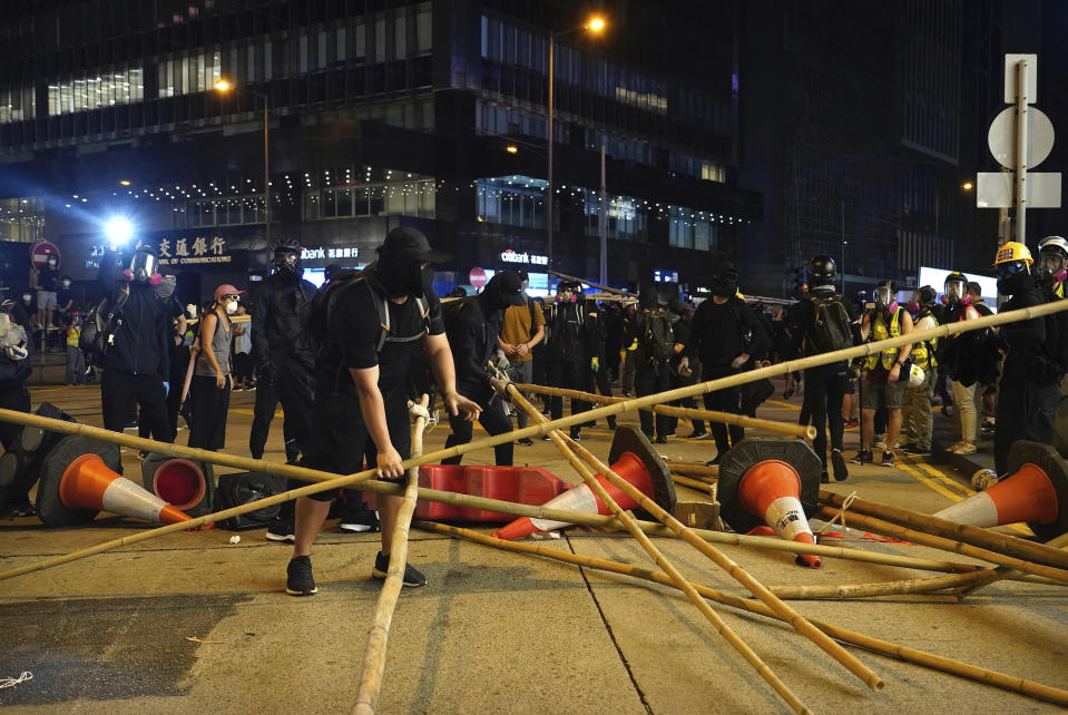 Demonstrators build a barricade in the street during a protest in Hong Kong, Saturday, Nov. 2, 2019. Anti-government protesters attacked the Hong Kong office of China's official Xinhua News Agency for the first time Saturday after chaos broke out downtown, with police and demonstrators trading gasoline bombs and tear gas as the protest movement approached the five-month mark. (AP Photo/Vincent Yu)