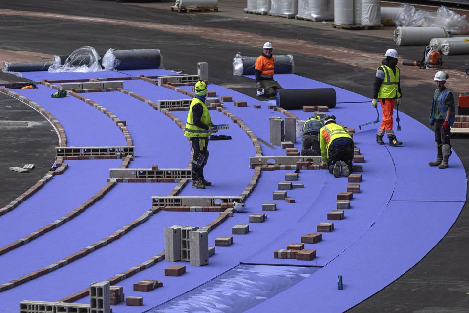 The purple athletics track at the Olympic Stadium, currently known as Stade de France, is being installed, in Saint-Denis, north of Paris, Tuesday, April 9, 2024. The Olympic Stadium will host the athletics events at the Paris 2024 Olympic Games. (AP Photo/Aurelien Morissard, File)