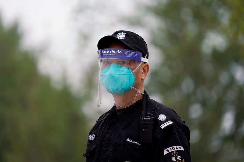 Security guard wearing face mask and face shield is seen in Wuhan