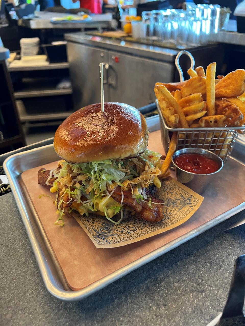 The Bacon Mac-N-Cheese Burger at Guy Fieri's Kitchen + Bar in Council Bluffs uses six cheeses, a smashed burger, bacon and garlic-buttered whole wheat buns.