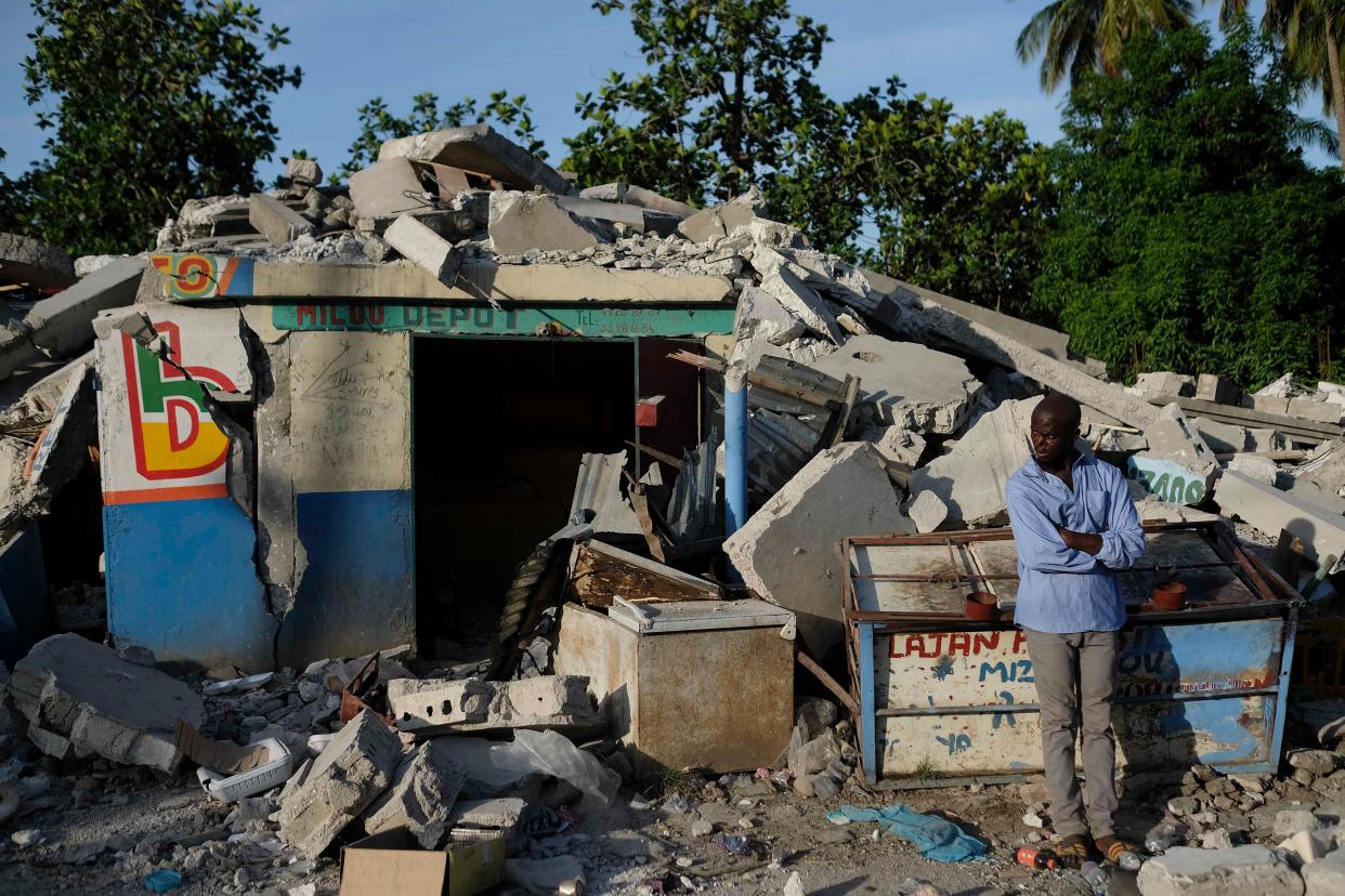 A man stands outside a collapsed shop in Saint-Louis-du-Sud, Haiti on Monday, Aug. 16, 2021. The death toll from a magnitude 7.2 earthquake in Haiti climbed to more than 1,200 on Sunday as rescuers raced to find survivors amid the rubble ahead of an approaching tropical storm.