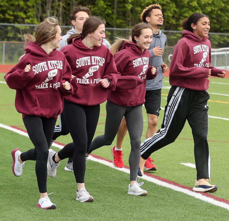 South Kitsap relay team members (left to right) Elise Hopper,  Savannah Kambich, Ella Hopper and Marissa Crane, warm up with a run around the field during pratice in Port Orchard on Tuesday, May 10, 2022. 
