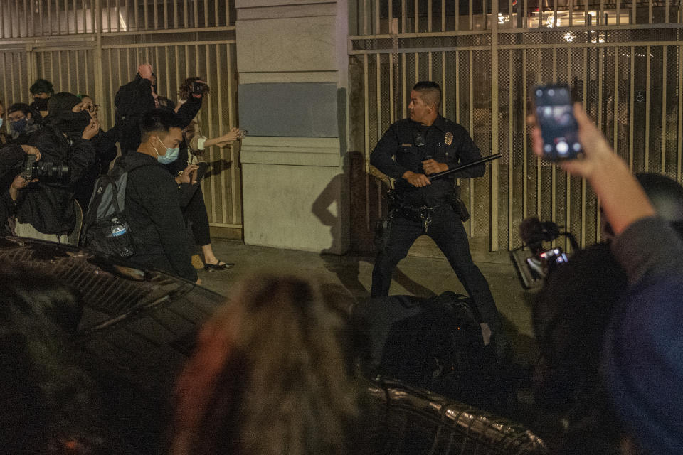 A police officer wiedling a baton is surrounded by a group of abortion rights demonstrators in Los Angeles on Tuesday night. (Ringo H.W. Chiu/AP Photo)