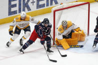 Nashville Predators' Alexandre Carrier, left, tries to stop Columbus Blue Jackets' Cam Atkinson, center, from taking a shot against Nashville Predators' Juuse Saros during the first period of an NHL hockey game Monday, May 3, 2021, in Columbus, Ohio. (AP Photo/Jay LaPrete)