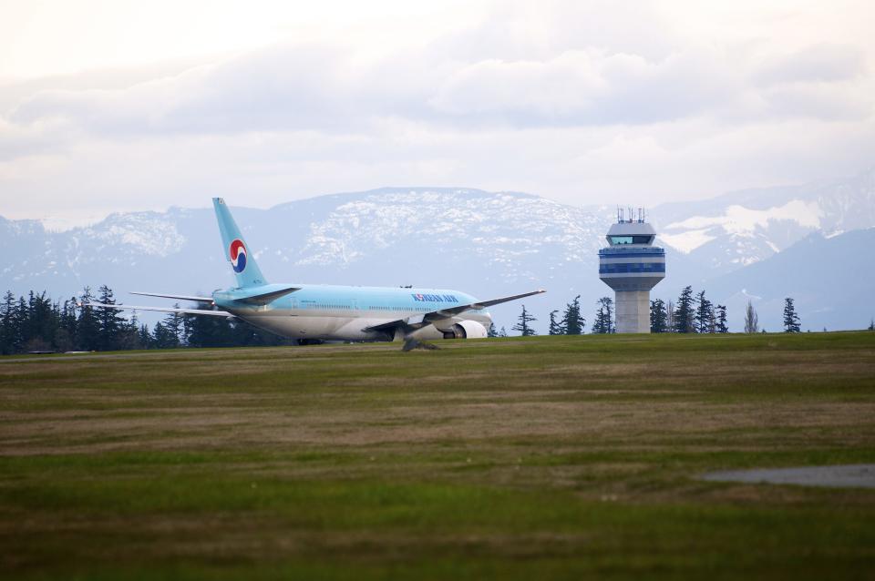 A Korean Air Boeing 777 rests on the runway of a Canadian Forces base in Comox, British Columbia on Tuesday April 10, 2012. The plane, en route from Vancouver, British Columbia to Seoul, diverted to Comox on Vancouver Island under escort by two U.S. fighter jets after the airline's U.S. call center received a call about a threat on board. (AP Photo/The Canadian Press, Richard Warrington)