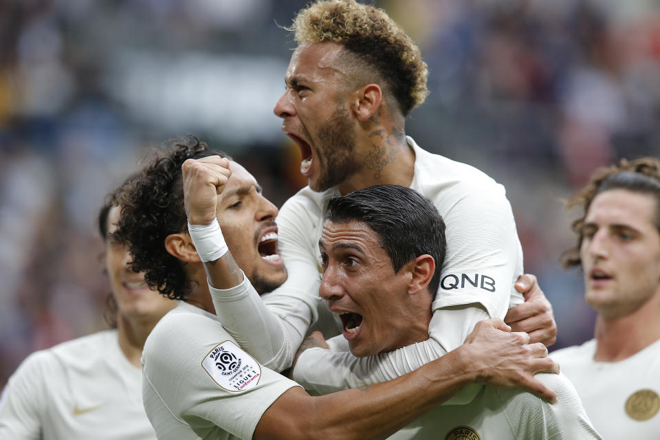 El delantero brasileño Neymar salta sobre su compañero argentino Angel Di María, quien anotó el primer gol del Paris Saint-Germain en la victoria 3-1 ante Rennes en la liga francesa, el domingo 23 de septiembre de 2018. (AP Foto/Michel Euler)