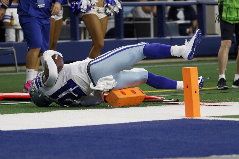 Dallas Cowboys running back Ezekiel Elliott (21) lands on sideline equipment after carrying the ball on a running play in the second half of an NFL football game against the New York Giants in Arlington, Texas, Sunday, Oct. 10, 2021. (AP Photo/Ron Jenkins)