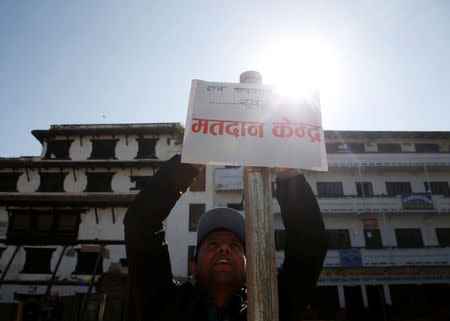 An election officer sets up a sign that reads "polling station" a day ahead of the parliamentary and provincial elections in Kathmandu, Nepal December 6, 2017. REUTERS/Navesh Chitrakar