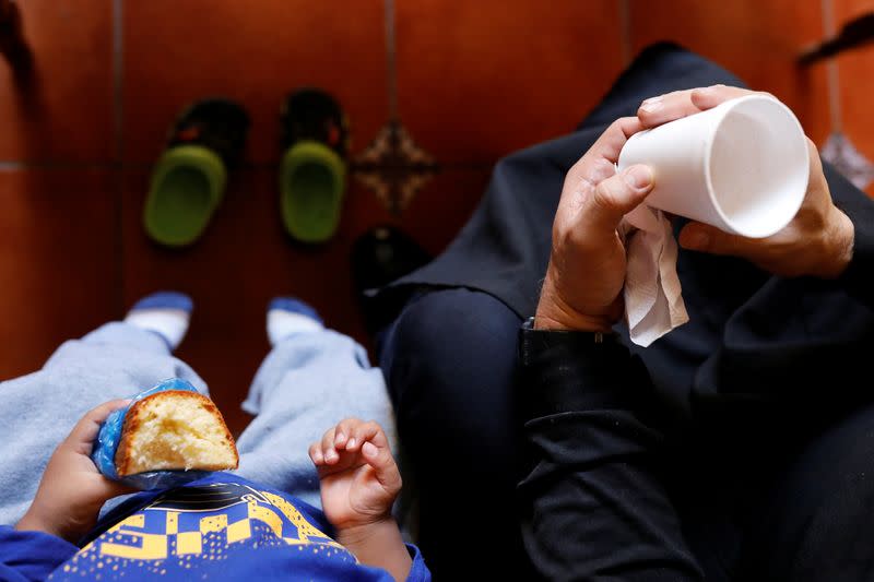 Fray Carlos Caceres chats with an unaccompanied child who was deported from the U.S., at a shelter in Guatemala City