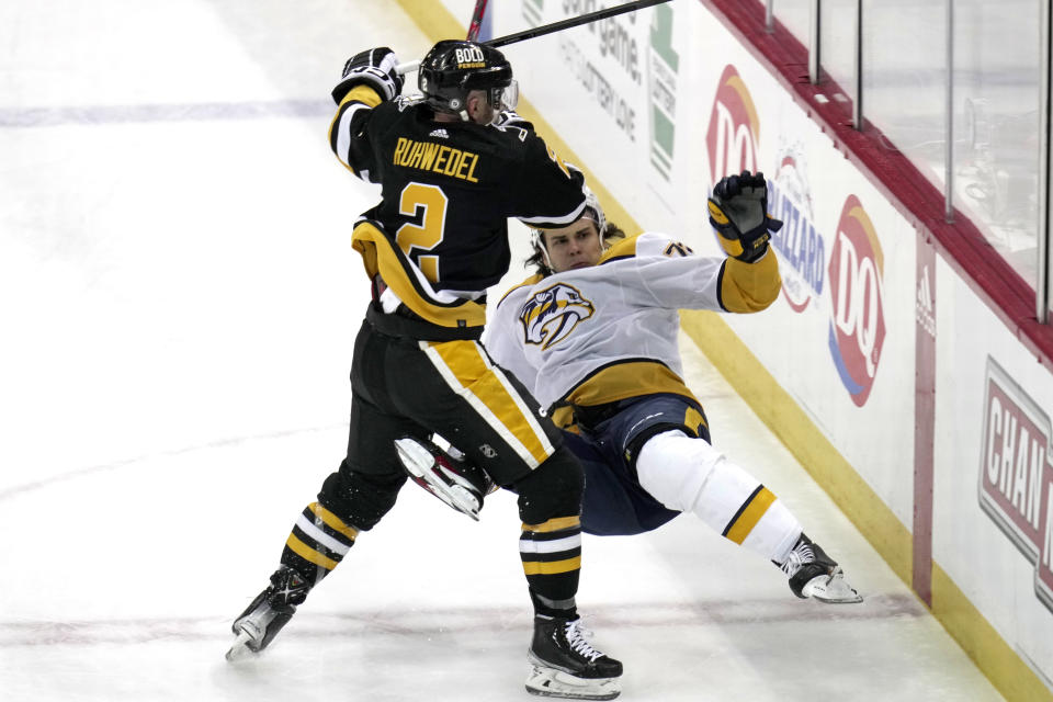 Pittsburgh Penguins' Chad Ruhwedel (2) checks Nashville Predators' Egor Afanasyev off his skates during the first period of an NHL hockey game in Pittsburgh, Thursday, March 30, 2023. (AP Photo/Gene J. Puskar)