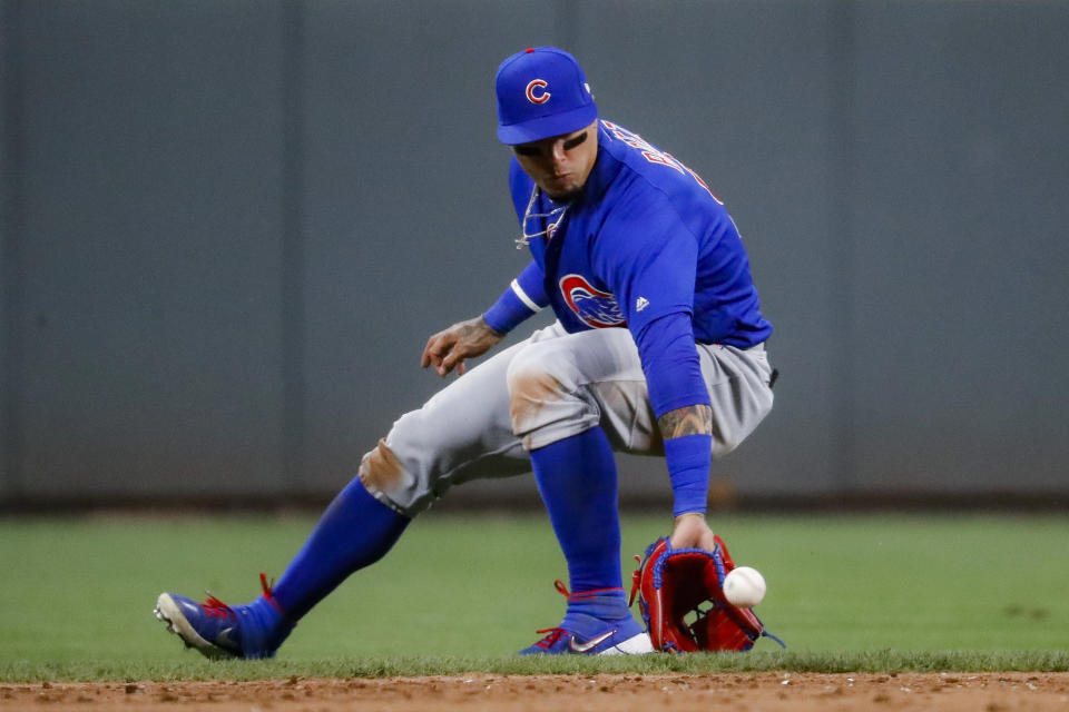 Chicago Cubs shortstop Javier Baez fields a ground ball by Cincinnati Reds' Jesse Winker in the sixth inning of a baseball game, Friday, Aug. 9, 2019, in Cincinnati. Winker was forced out at first base. (AP Photo/John Minchillo)