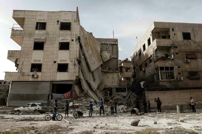 People inspect a hospital, damaged following an air strike a rebel-controlled town in the eastern Ghouta region on the outskirts of the capital Damascus on May 1, 2017