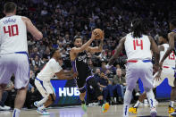 Sacramento Kings forward Trey Lyles (41) moves the ball while defended by Los Angeles Clippers guard Norman Powell, second from left, during the first half of an NBA basketball game Tuesday, April 2, 2024, in Sacramento, Calif. (AP Photo/Godofredo A. Vásquez)