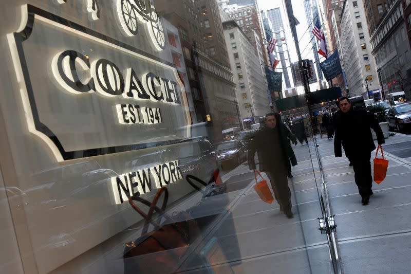 People walk past a Coach store on Madison Avenue in New York