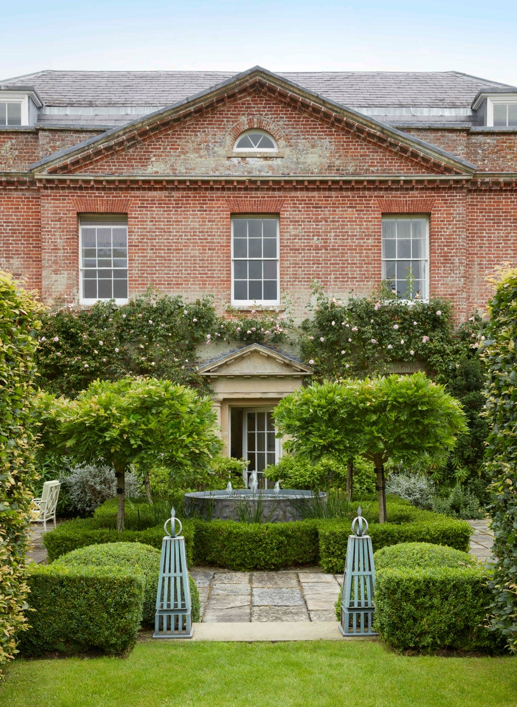 along the rear of the home climbing roses cloak aged brickwork