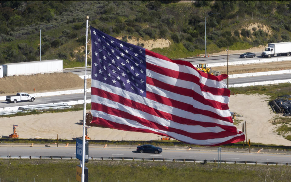 LOS ANGELES COUNTY, CA MARCH 14: A flag at a shopping center in Stevenson Ranch billows in the gusty Santa Ana winds that blew through the Southland felling trees in some areas, prompting warnings of hazardous driving conditions and possible damage to power lines. Photographed in Stevenson Ranch, Los Angeles County, CA on Thursday, March 14, 2024. (Myung J. Chun / Los Angeles Times via Getty Images)