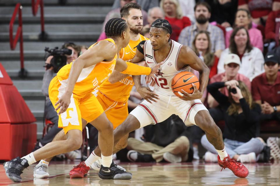 Feb 14, 2024; Fayetteville, Arkansas, USA; Arkansas Razorbacks guard Tramon Mark (12) drives against Tennessee Volunteers guard Santiago Vescovi (25) during the first half at Bud Walton Arena. Mandatory Credit: Nelson Chenault-USA TODAY Sports