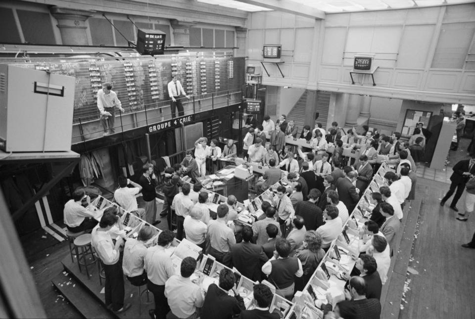 Black and white photo of a room full of traders in the Paris Stock Exchange on Black Monday