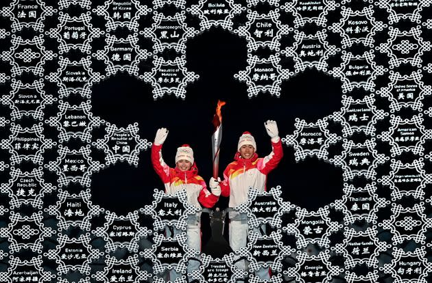 The Olympic cauldron is lit by Dinigeer Yilamujiang, left, and Zhao Jiawen of China during the Feb. 4, 2022, opening ceremony of the Beijing Winter Olympic Games at National Stadium in Beijing, China. (Photo: Ramsey Cardy/Sportsfile via Getty Images)