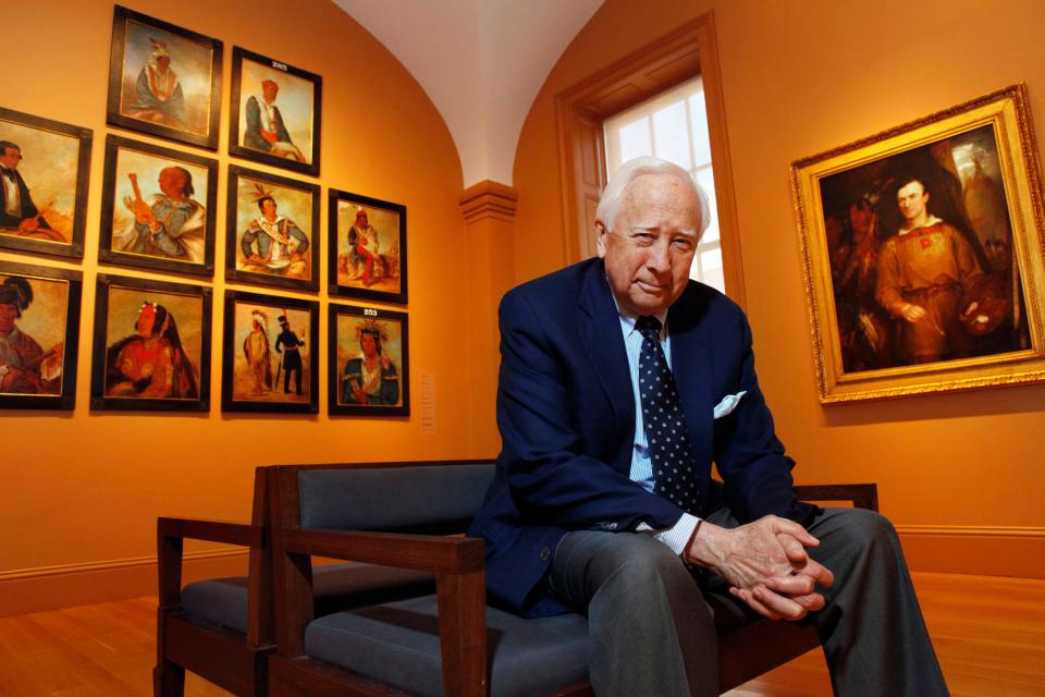 Historian and author David McCullough poses with art by George Catlin, one of the artists featured in his new book, "The Greater Journey," at the Smithsonian American Art Museum, in Washington on May 13, 2011. McCullough, the Pulitzer Prize-winning author whose lovingly crafted narratives on subjects ranging from the Brooklyn Bridge to Presidents John Adams and Harry Truman made him among the most popular and influential historians of his time, died Sunday in Hingham, Massachusetts. He was 89.