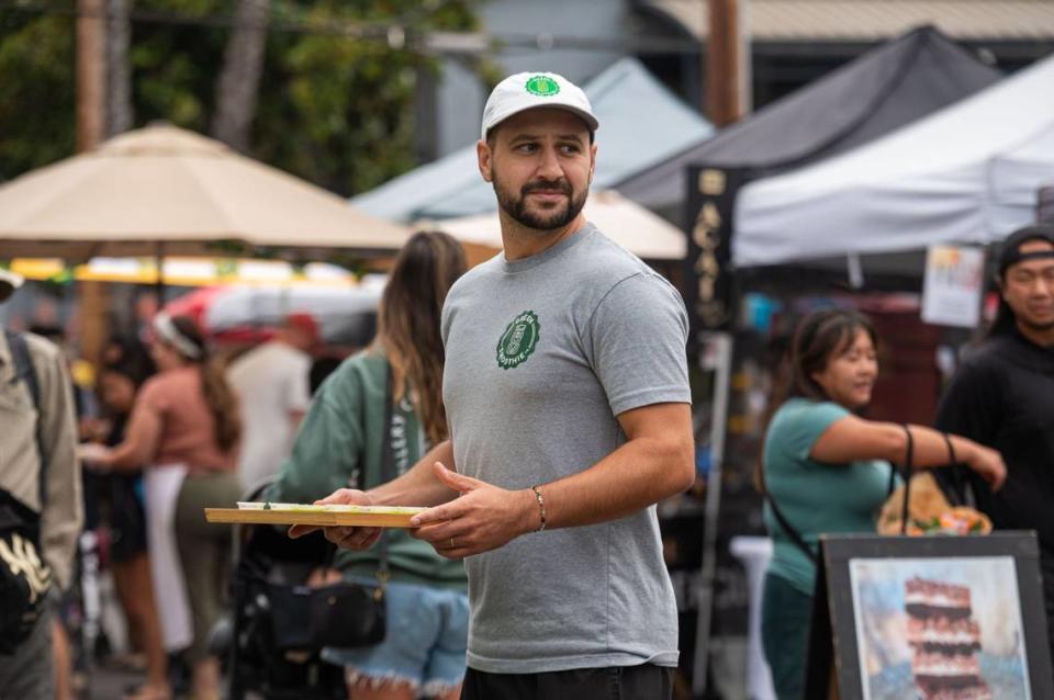 Green Smoothie Co. co-owner Brady Bisgaard offers free samples at the Midtown Farmers Market in Sacramento on July 27.