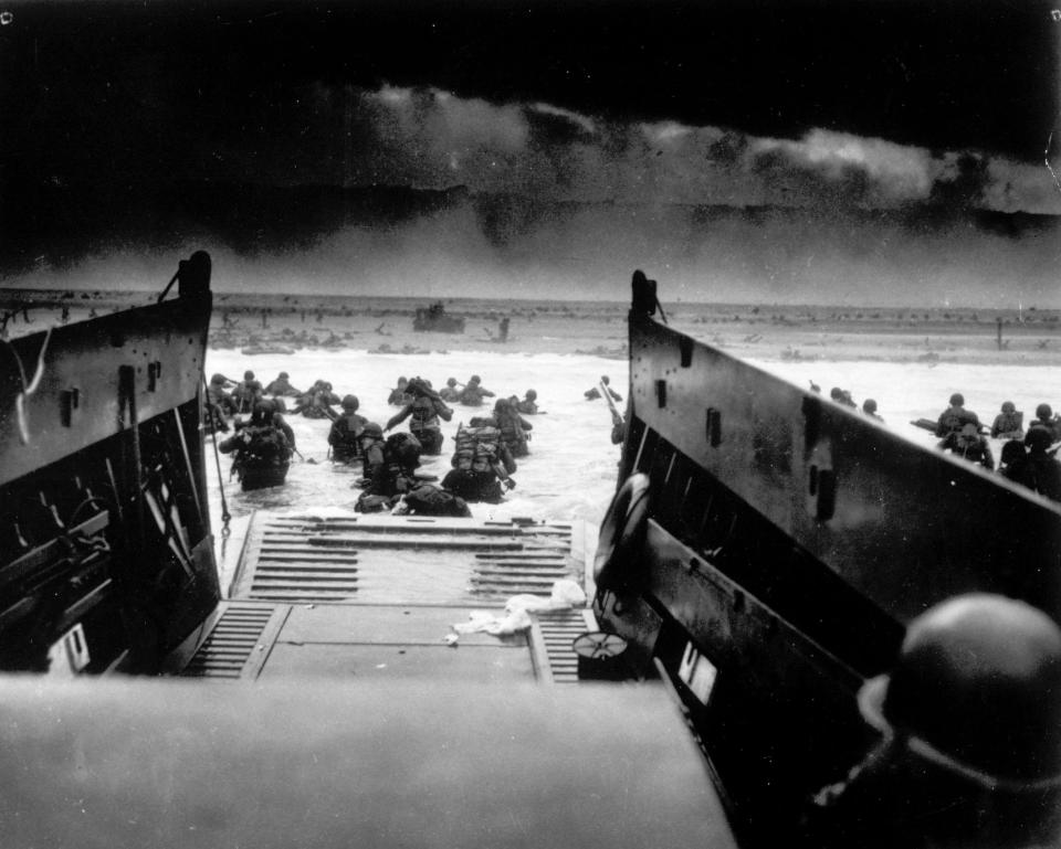 While under attack of heavy machine gun fire from the German coastal defense forces, American soldiers wade ashore off the ramp of a U.S. Coast Guard landing craft in this June 6, 1944 file photo, during the Allied landing operations at Normandy.