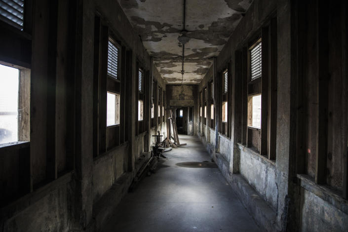 <p>A corridor leading to the hospital wards to Island Three of Ellis Island. The wards are filled with long and short corridors that are filled eerie shadows and soft light. (Photo: Gordon Donovan/Yahoo News) </p>