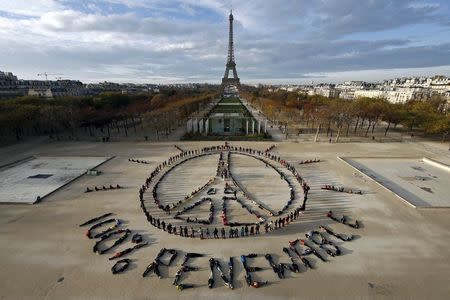 Hundreds of environmentalists arrange their bodies to form a message of hope and peace in front of the Eiffel Tower in Paris, France, December 6, 2015, as the World Climate Change Conference 2015 (COP21) continues at Le Bourget near the French capital. REUTERS/Benoit Tessier