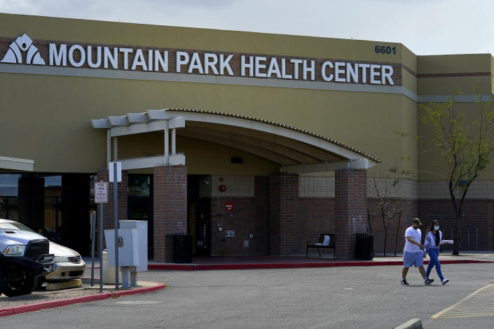 People exit the nonprofit Mountain Park Health Center, Thursday, March 30, 2023, in Phoenix. As heat waves fueled by climate change arrive earlier, grow more intense and last longer, people over 60 who are more vulnerable to high temperatures are increasingly at risk of dying from heat-related causes. Heat related deaths are challenging community health systems, utility companies, apartment managers and local governments to better protect older people when temperatures soar.(AP Photo/Matt York)