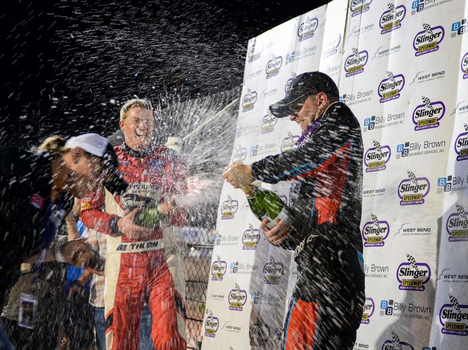 Slinger Nationals winner William Byron, right, sprays bubbly with third-place finisher Derek Thorn on the Slinger Speedway victory deck.