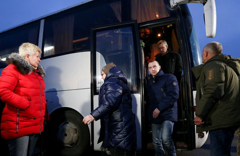 Ukrainian get off a bus after the exchange of prisoners of war between Ukraine and the separatist republics near the Mayorsk crossing point in Donetsk region