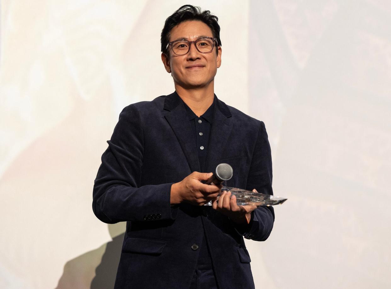 Actor Lee Sun Kyun receives the award for "Excellent Achievement in Film" during the introduction of the "Killing Romance" Midwest Premiere at AMC New City 14