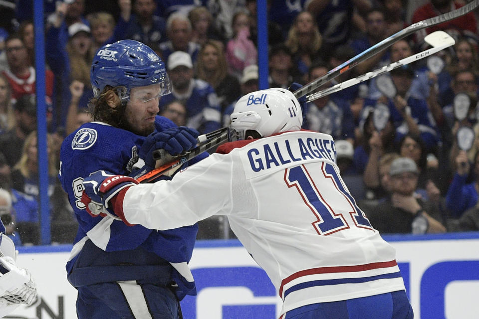 Tampa Bay Lightning defenseman Mikhail Sergachev checks Montreal Canadiens right wing Brendan Gallagher (11) during the third period in Game 1 of the NHL hockey Stanley Cup finals, Monday, June 28, 2021, in Tampa, Fla. (AP Photo/Phelan Ebenhack)