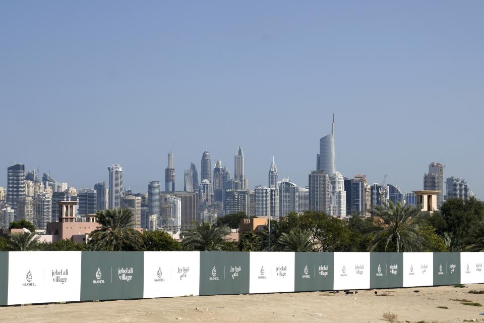 Towers in the Dubai Marina district and Jumeirah Lake Towers rise behind the advertising billboards of a new development in Dubai, United Arab Emirates, Wednesday, Feb. 1, 2023. For the first time since a 2009 financial crisis nearly brought Dubai to its knees, several major abandoned real estate projects now show signs of life. As with its other booms, war again is driving money into Dubai and buoying its economy. This time it's Russian investors fleeing Moscow’s war on Ukraine, rather than people escaping Mideast battlefields. (AP Photo/Kamran Jebreili)