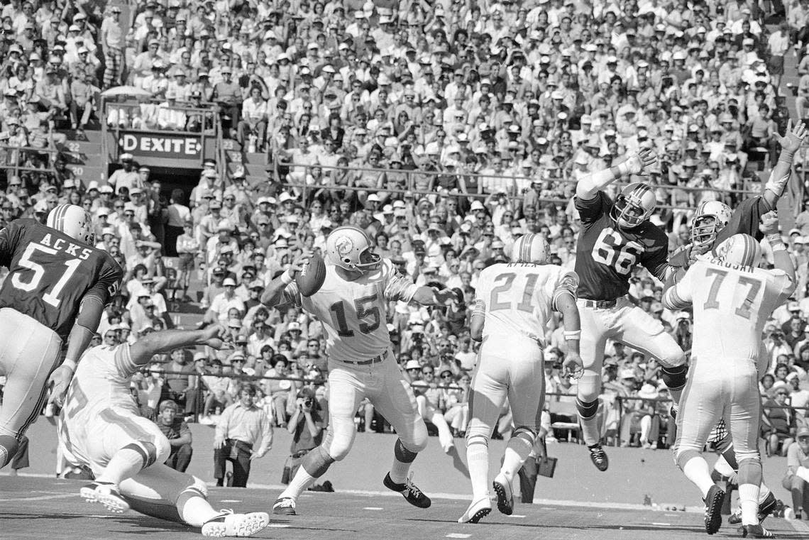 Miami Dolphins quarterback Earl Morrall gets to hurl another pass in their game against the New England Patriots Sunday afternoon, Nov. 12, 1972 at Miami’s Orange Bowl. Up in the air to block is Patriot linebacker Ed Weisacosky (66) and blocking for Morrall is Jim Kiick (21). The Dolphins, pro football’s only undefeated team, enjoyed a 31-0 halftime lead.