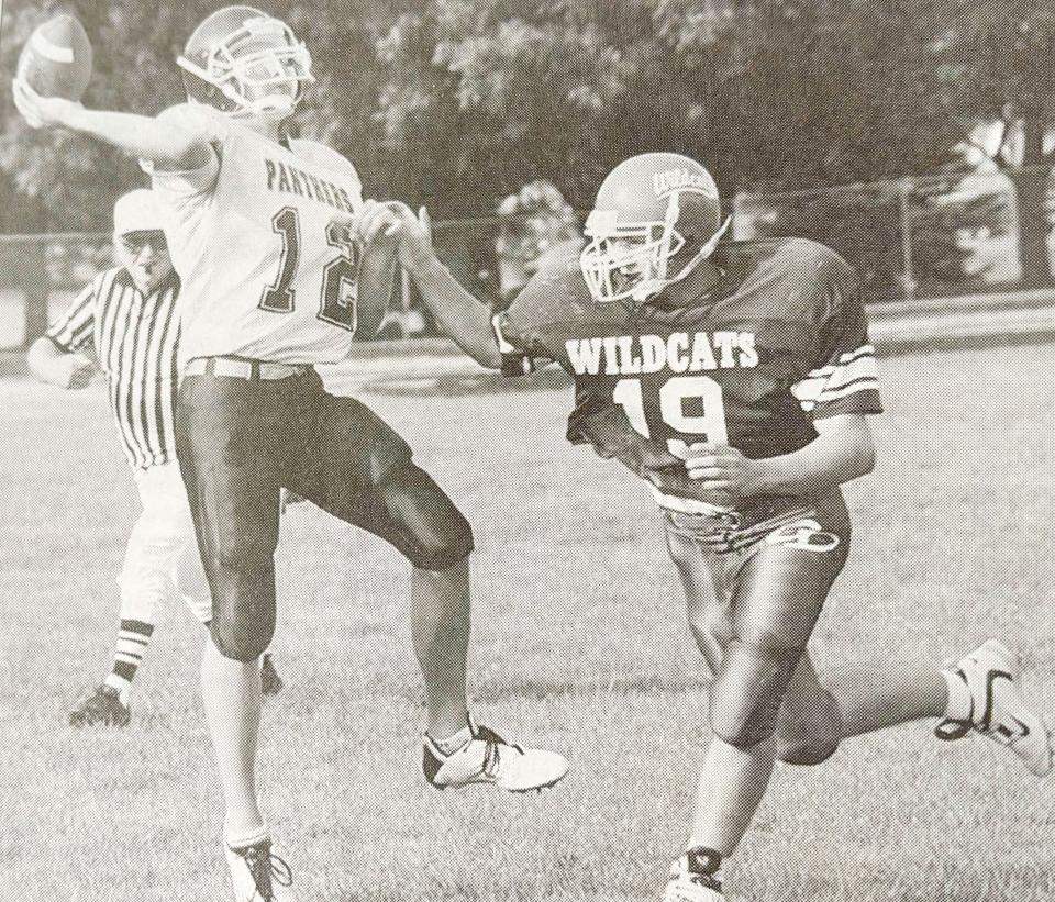 Great Plains Lutheran quarterback Stuart Schlomer passes the ball while being pressured by Grant-Deuel's Andrew Brehmer during an Eastern Coteau Conference football game in September 2003 at Allen Mitchell Field.
