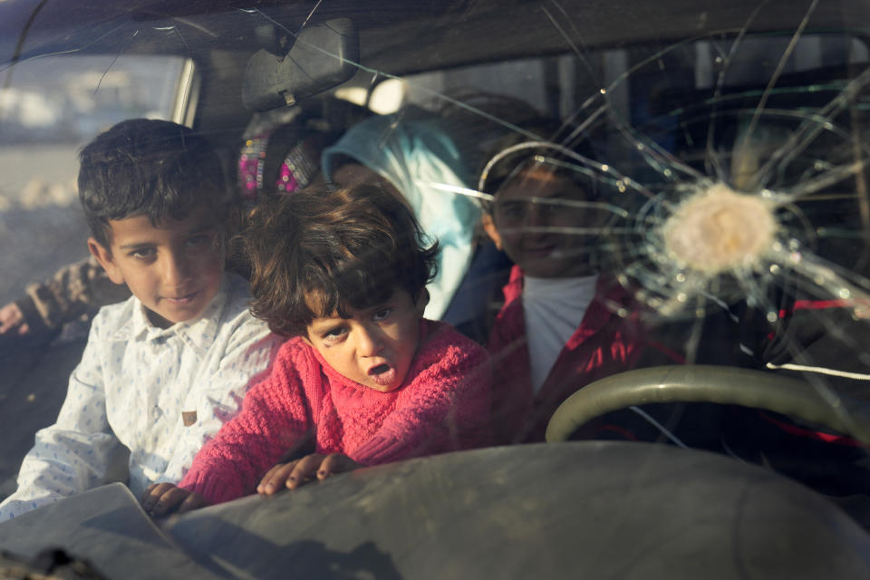 Syrian refugee child sit inside a car with their family, as they wait at a gathering point to cross the border back home to Syria, in the eastern Lebanese border town of Arsal, Lebanon, Wednesday, Oct. 26, 2022. Several hundred Syrian refugees boarded a convoy of trucks laden with mattresses, water and fuel tanks, bicycles – and, in one case, a goat – Wednesday morning in the remote Lebanese mountain town of Arsal in preparation to return back across the nearby border.(AP Photo/Hussein Malla)