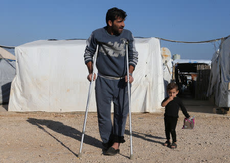 A Syrian refugee walks on crutches at a refugee camp in Akkar, northern Lebanon, November 27, 2018. REUTERS/Mohamed Azakir