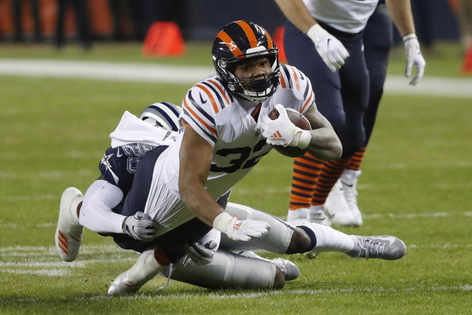 Chicago Bears' David Montgomery (32) is tackled by Dallas Cowboys' Xavier Woods (25) during the first half of an NFL football game, Thursday, Dec. 5, 2019, in Chicago. (AP Photo/Charles Rex Arbogast)