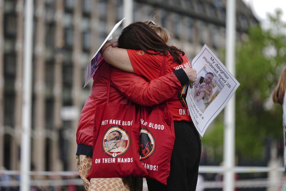 Infected blood campaigners hug during a gathering at Parliament Square, ahead of the publication of the final report into the scandal, in London, Sunday, May 19, 2024. The final report of the U.K.’s infected blood inquiry will be published Monday, six years after it started its work. The inquiry heard evidence as to how thousands of people contracted HIV or hepatitis from transfusions of tainted blood and blood products in the 1970s and 1980s. (Aaron Chown/PA via AP)