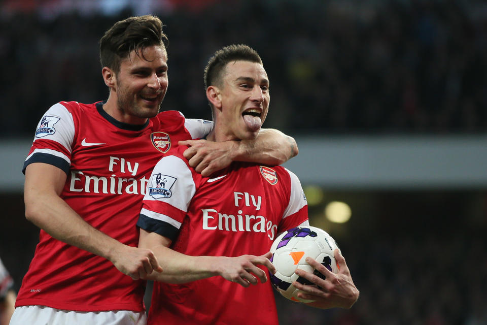 Arsenal's Laurent Koscielny, right, celebrates with teammate Oliver Giroud after scoring the opening goal during their English Premier League soccer match between Arsenal and Newcastle United at the Emirates stadium in London, Monday, April 28, 2014. (AP Photo/Alastair Grant)